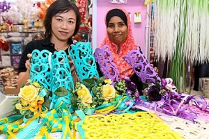 Ideal as decorations: Wong (left) and her staff holding up the decorative pieces they have created using colourful foam sheets, artificial flowers and ribbon ketupat.